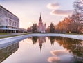 Sunset campus of Moscow university under cloudy sky with water reflections