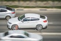 White BMW X6 on the city road. Fast moving car on Moscow streets. Compliance with speed limits on the road. Side view shot of SUV