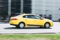 Yellow taxi car fast moving on the street. Side view of taxi in motion. Rapid and inexpensive means of getting around the city Royalty Free Stock Photo