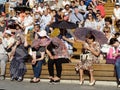 Spectators sitting in the stands during a performance on a hot day