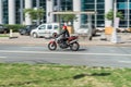 Biker ride BMW F800 GT motorcycle on the city road with motion blurred background. Motorcyclist in red helmet and jacket on black