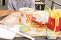 MOSCOW, RUSSIA - AUGUST 02, 2019: Burgers, french fries, nuggets and soft drink lying in mess on a tray on a table in Macdonalds