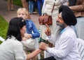 An elderly bearded Indian in a black turban gives a woman an acupressure of the hand