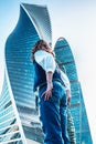 Moscow / Russia - AUGUST 18, 2018: girl stand of the business center. Woman in jeans near office buildings. Glass skyscrapers on a