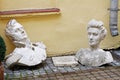 Old plaster busts of a man and woman from the time of 1812 lying on the paving stones in the Royalty Free Stock Photo