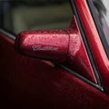 MOSCOW, RUSSIA - AUGUST 26, 2017: Rear view mirror from with logo on a vintage red Cadillac car close-up, selectiv focus Royalty Free Stock Photo