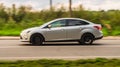 Silver car Ford Focus sedan Mk III fast speed driving on the country road