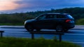 Skoda Kodiaq driving on the country road at dusk. Side view of SUV in motion on the background of evening sunset sky Royalty Free Stock Photo