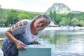 Woman drinks spring water from fountain. Drinking mineral water in fresh air.