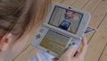 Woman gamer using game console Nintendo 3ds with AR app - close up view