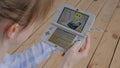 Woman gamer using game console Nintendo 3ds with AR app