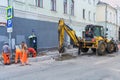 Working team change curbstones with an excavator. Road works on the city street editorial