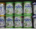 03-08-2019 Moscow, Russia. Baby food milk formula organic NAN Nestle in large white green metal cans on a store shelf Royalty Free Stock Photo