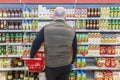 Moscow, Russia, 07/04/2020: A bald man chooses fruit juices in a store. A large assortment. Back view