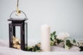 Moscow, Russia - 06 10 2018: black metal lamp with white roses, candle and flowers on light background, home decor Royalty Free Stock Photo