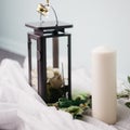 Moscow, Russia - 06 10 2018: black metal lamp with white roses, candle and flowers on light background, home decor Royalty Free Stock Photo