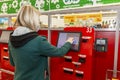 Moscow, Russia, 03/26/2020: A blonde woman pays for purchases at a supermarket in a self-service terminal