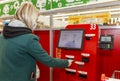 Moscow, Russia, 03/26/2020: A blonde woman pays for purchases at a supermarket in a self-service terminal