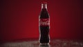 Moscow, Russia - 14 04 2020: Bottle glass of classic Coca-Cola rotate on mirrored table red background. Nice footage of