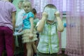 A boy holding his ready picture behind face.