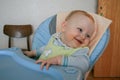 Cute baby boy sitting on the baby chair and waiting dinner.