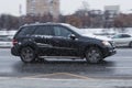 Black Mercedes ML W164 SUV car at winter city street in motion