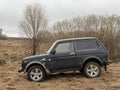 Black Russian off-road car Lada Niva 4x4 VAZ 2121 / 21214 parked on the field.