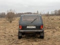 Black Russian off-road car Lada Niva 4x4 VAZ 2121 / 21214 parked on the field.