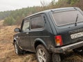 Black Russian off-road car Lada Niva 4x4 VAZ 2121 / 21214 parked on the field.