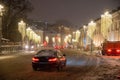 Moscow, Russia - December 27, 2022: Car drives down a snowy street in a cold and deserted Moscow on a dark winter evening