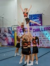 Moscow, Russia - December 22, 2019: Cheerleader teen girls in sports uniform perform a trick, well-coordinated teamwork