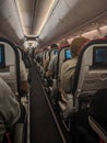 Moscow, Russia - December 1, 2019: Interior of airplane, people sit in the passenger seats of the aircraft. In the aisle, the Royalty Free Stock Photo