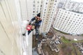 Moscow, Russia - December 18. 2018. Mountaineer employee of public services warms the facade of residential building.