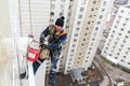 Moscow, Russia - December 18. 2018. Mountaineer employee of public services warms the facade of residential building.