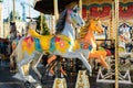 Moscow, Russia - December 1, 2019: Multicolored horses of the festival carousel close-up. A fun ride for children, a gray toy