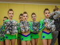 Moscow, Russia - December 22, 2019: Teenage girls, athletes in bright green leotards, with pom-pons waiting start show