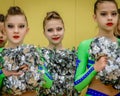 Moscow, Russia - December 22, 2019: Teenage girls, athletes in bright green leotards, with pom-pons waiting start show