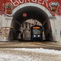 Moscow, Russia - December 08, 2018. Tram goes inside of the old archway covered with graffiti in Moscow