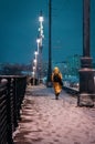 A woman walks through the city on a cold winter evening