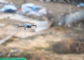 A drone flies in the air against a background of blurry large open space