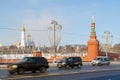 Black SUV and two minibuses are quickly moving along the highway on background of of the Kremli