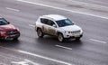 car Jeep Compass moving on the street. SUV vehicle driving along wet slippery street in city, aerial front side view