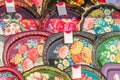Moscow, Russia - February 11, 2018: Colorful floral painted metal lacquer trays on display for sale at traditional fair