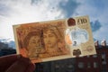 Moscow, Russia, February 2020: The hand holds a brand new 10 pound note made of polymer plastic with a portrait of the Queen and