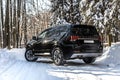 Moscow, Russia - February 15, 2021: Kia Mohave 2021 black SUV parked in the forest in winter. On the road. Alone in the woods back Royalty Free Stock Photo