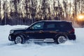 Moscow, Russia - February 15, 2021: Kia Mohave 2021 black SUV stands on the road in winter forest, snowdrifts. Side view