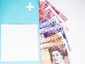 Moscow, Russia, February 2020: A pile of ten, twenty and fifty pound notes is visible from a blue folder with an airplane and a