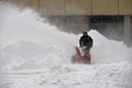 Moscow, Russia, February 13, 2021: Snow removal with snow blower during snowfall, Olympic Village, Michurinsky prospect