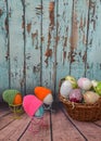 spring easter still life, easter eggs with bird paws and in colorful knitted hats look at easter eggs in a basket