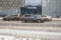 Urban landscape with cars driving on snowy road during snow blizzard. Old gray Opel Astra H hatchback in motion on slippery street